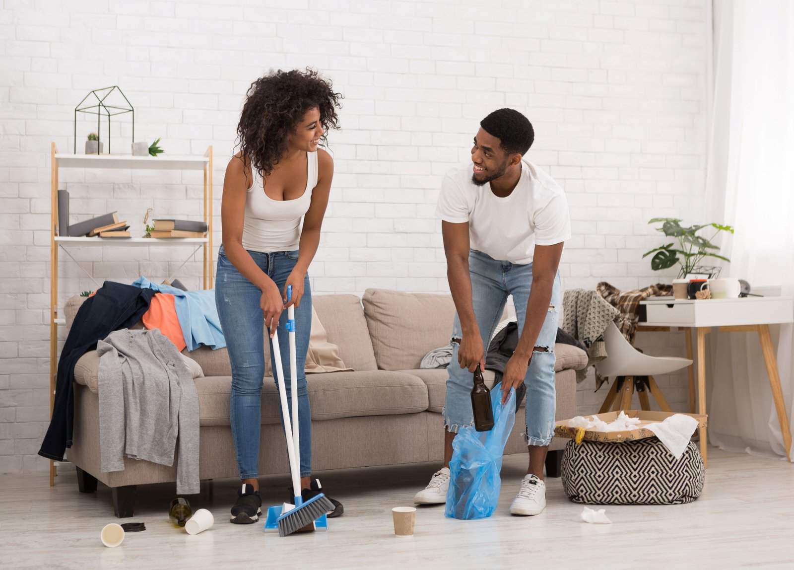 Husband and wife helping each other cleaning the house.