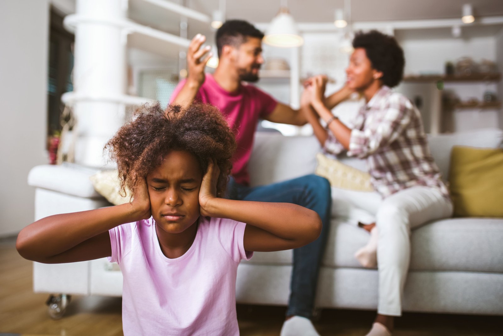 Couples fighting infront of their child in living room.