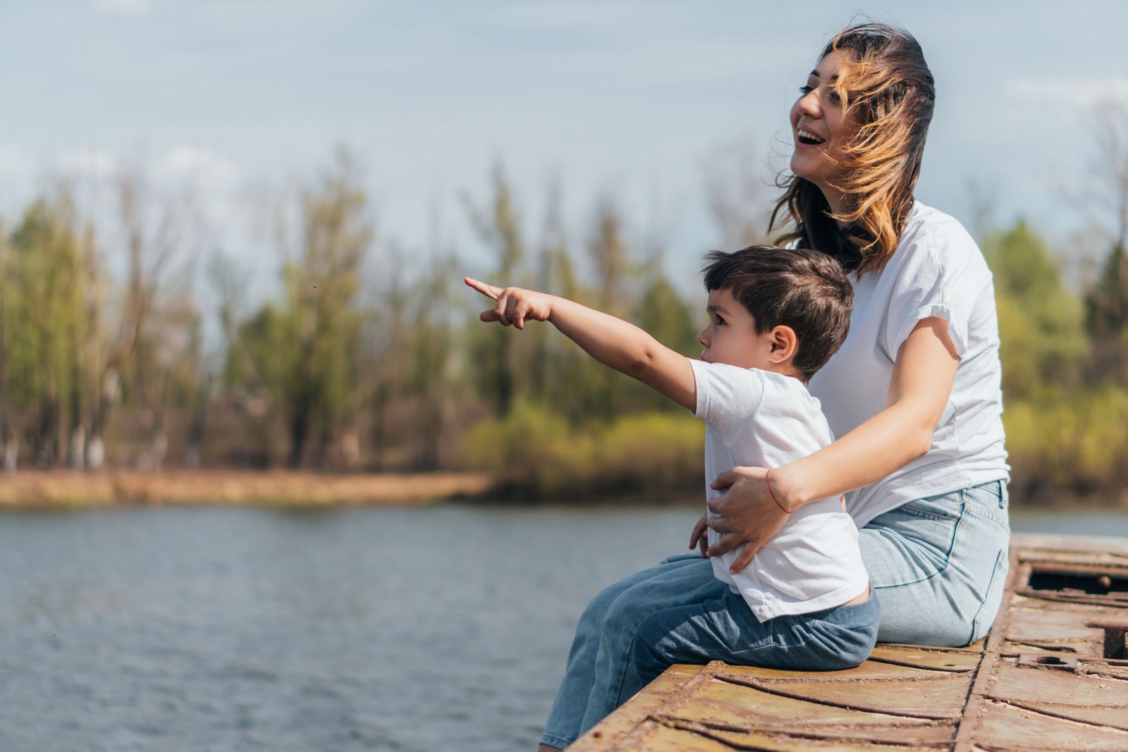Mother is having a fun time with her son by the lake.